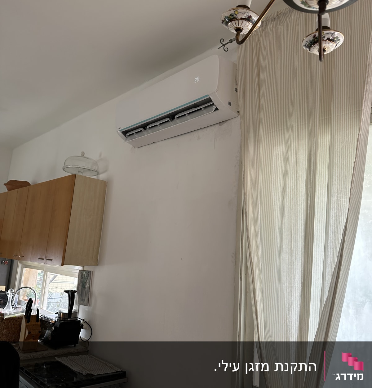 מזגן מותקן על קיר עם תצוגת טמפרטורה 26 מעלות